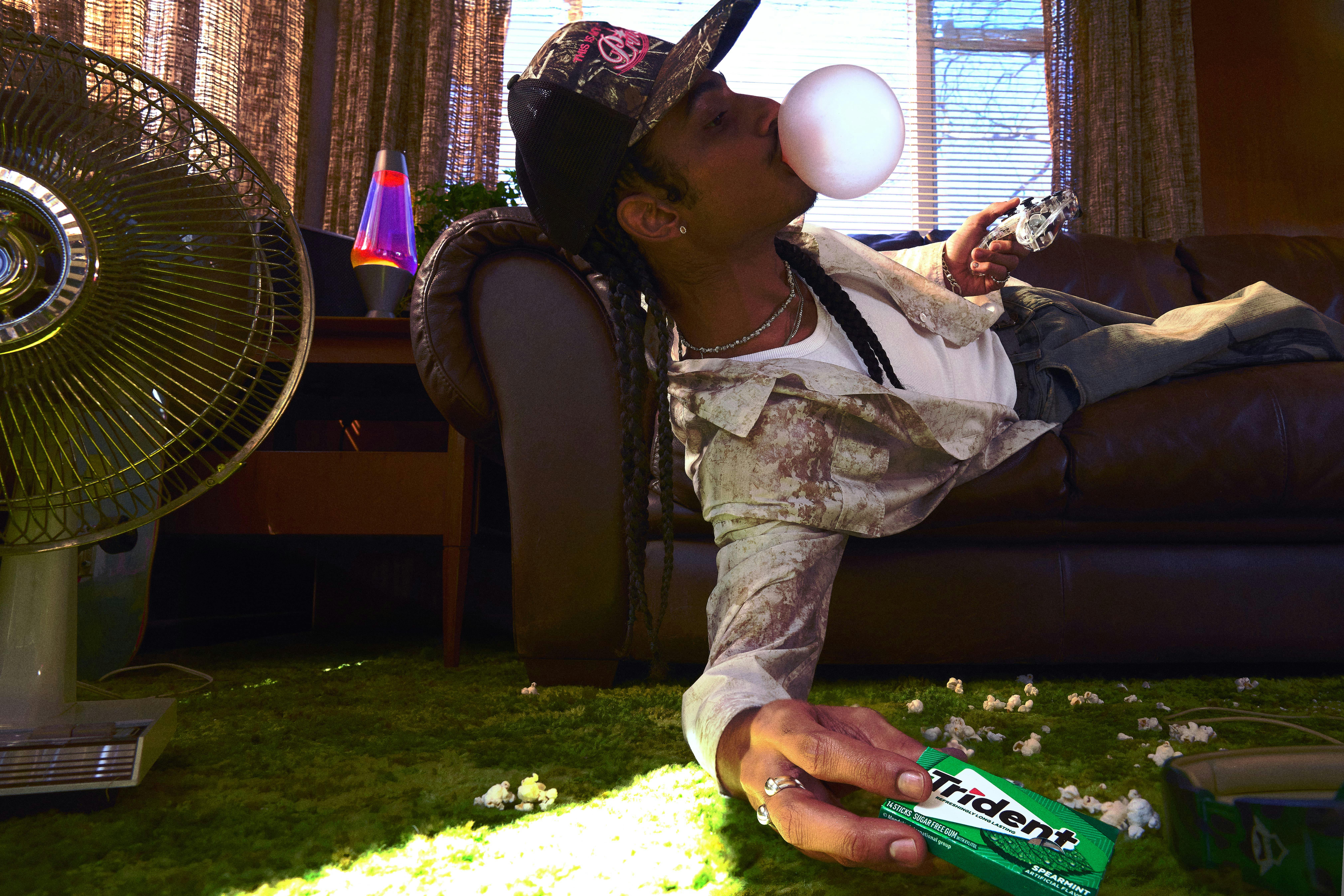 Man on couch chewing gum and playing video games