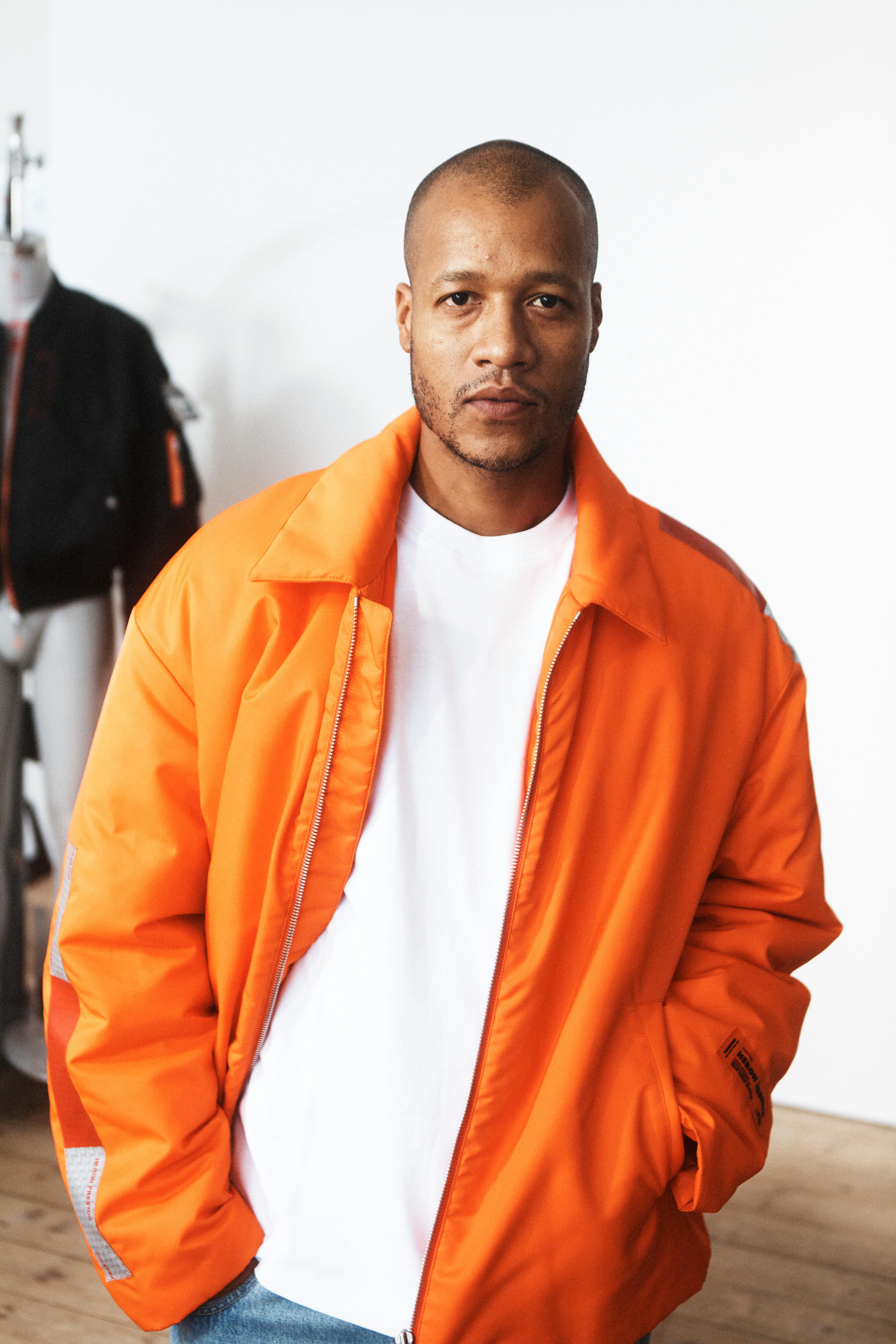 Heron Preston & H&M's menswear directors reveal the H2 collaboration, sitting in a room with mannequins and clothes on racks