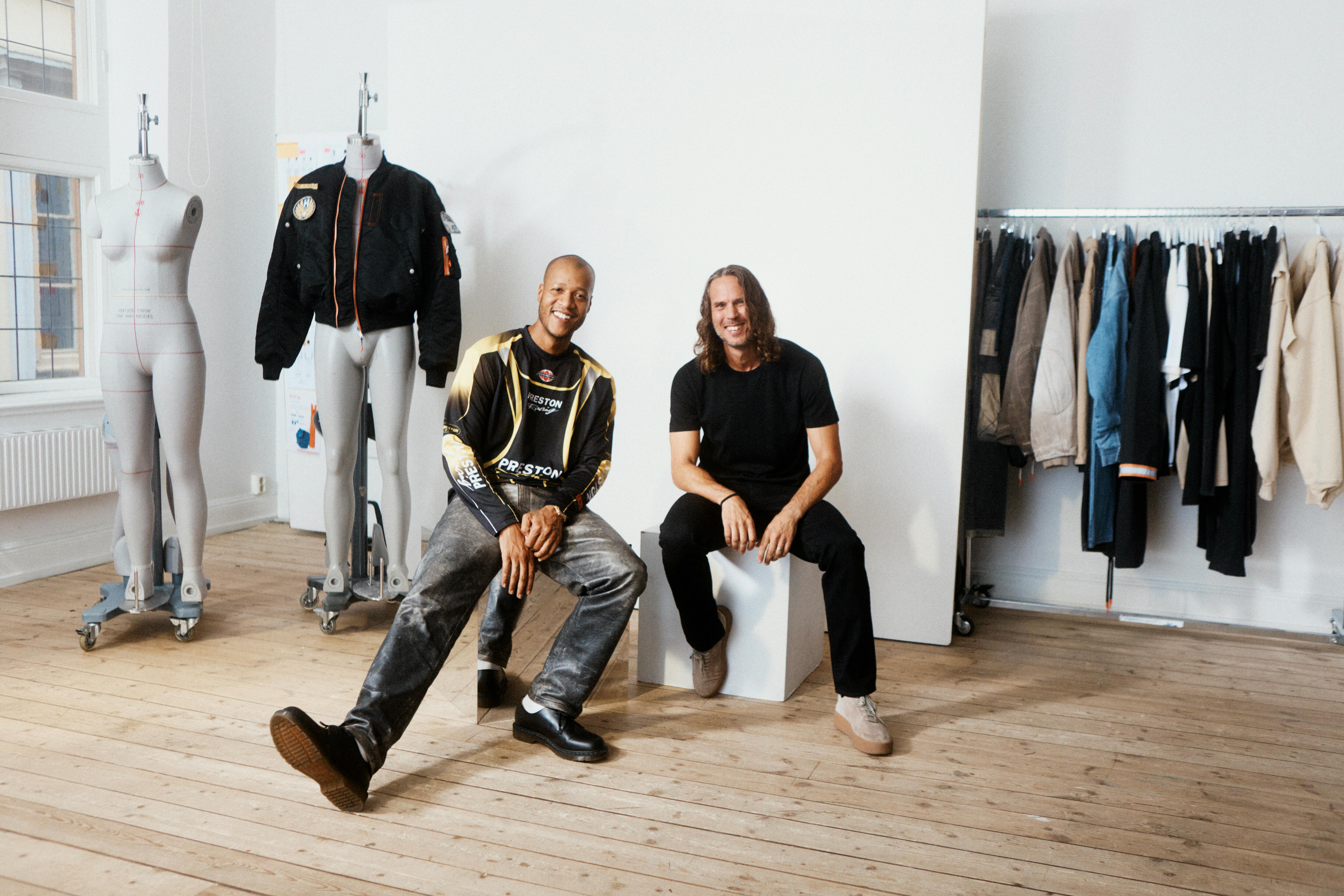 Heron Preston & H&M's menswear directors reveal the H2 collaboration, sitting in a room with mannequins and clothes on racks