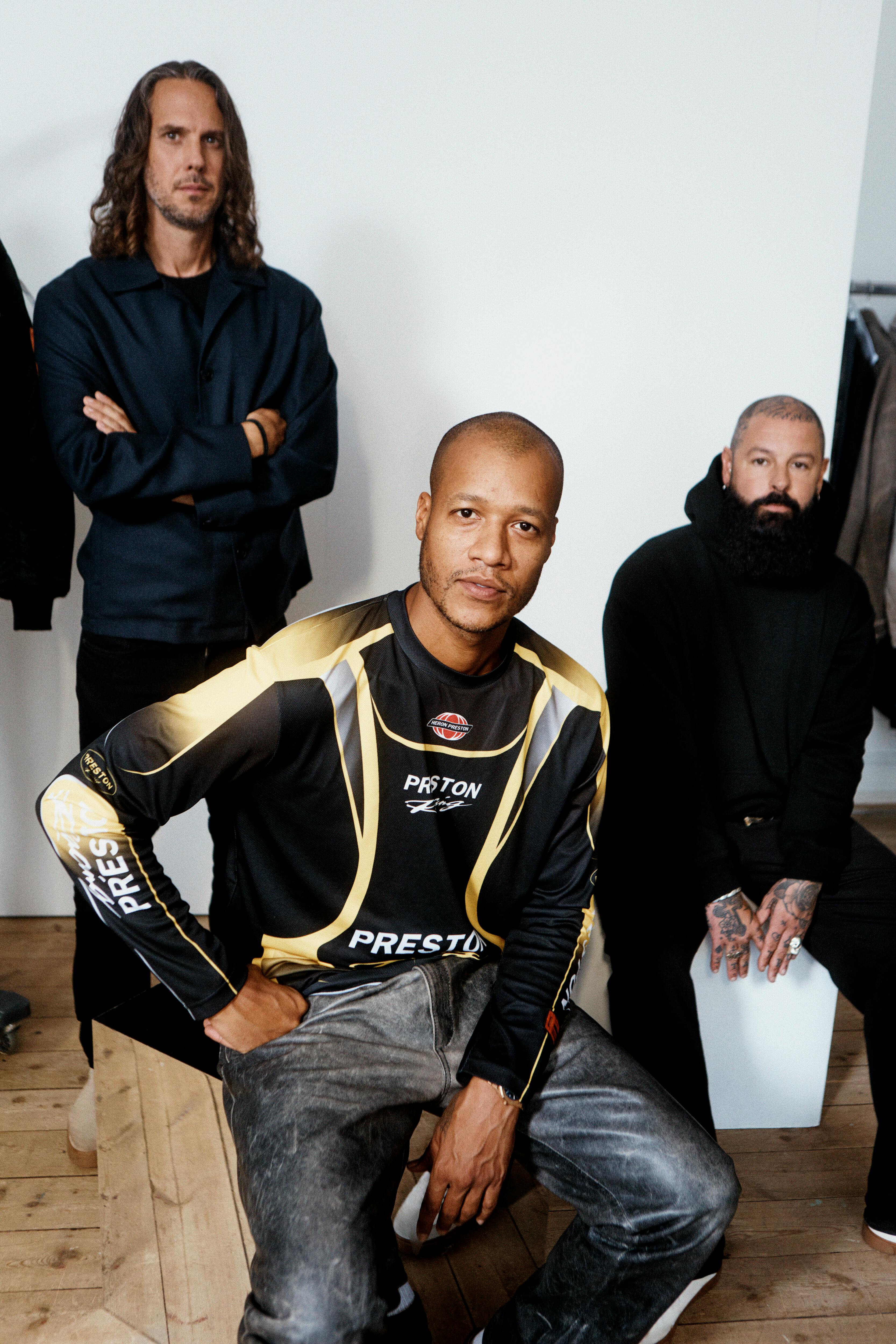 Heron Preston & H&M's menswear directors reveal the H2 collaboration, sitting in a room with mannequins and clothes on racks
