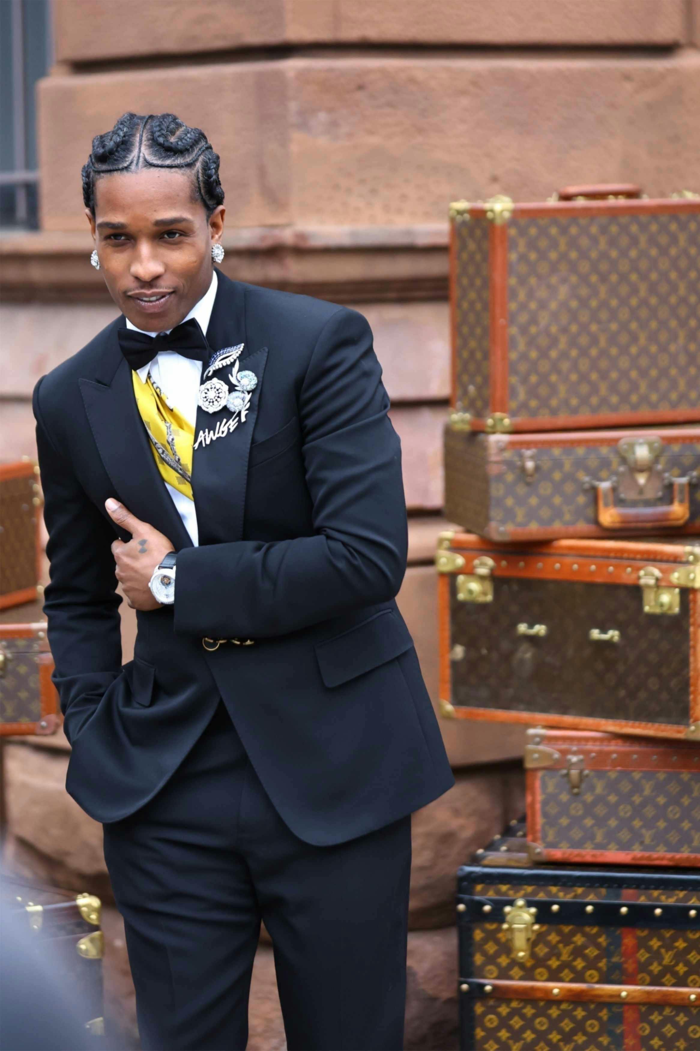 asap rocky wears an awge pin and louis vuitton suit