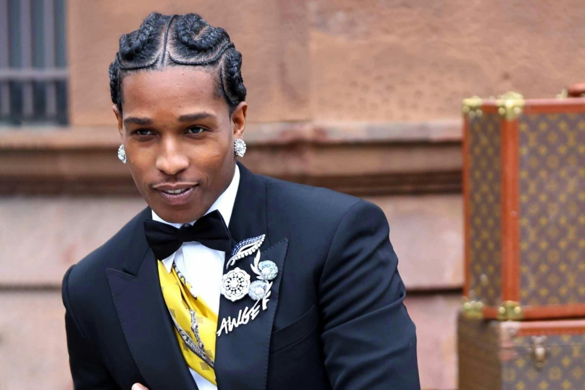 asap rocky wears an awge pin and louis vuitton suit