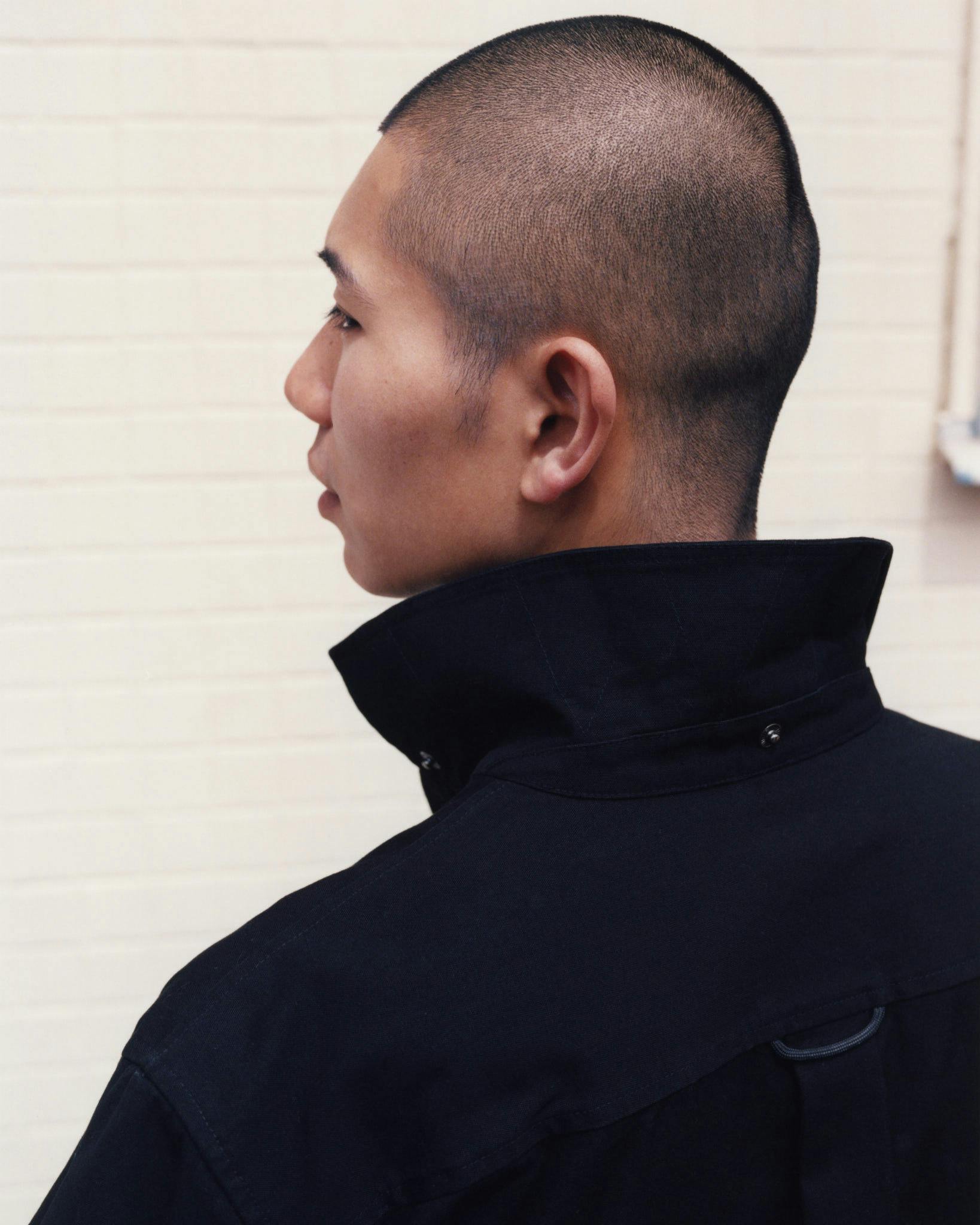 Close profile showing the raised collar of a dark Morrow coat