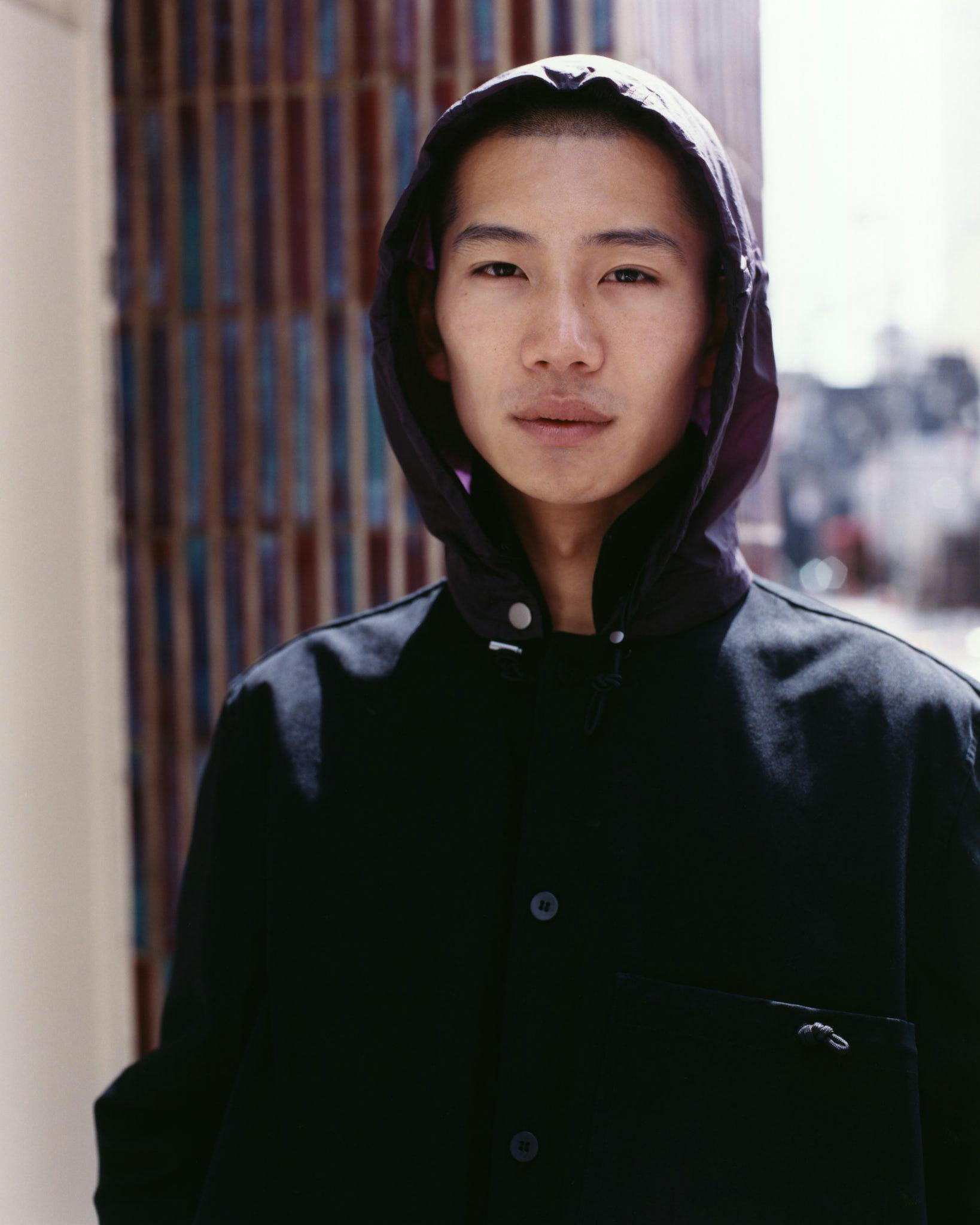 Close portrait of a model in a dark Morrow hooded coat