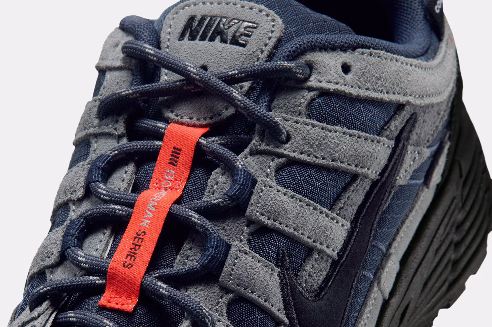 Close-up of the Nike P-6000 Thunder Blue laces, grey suede and orange Bowerman Series tab. Photo via Highsnobiety