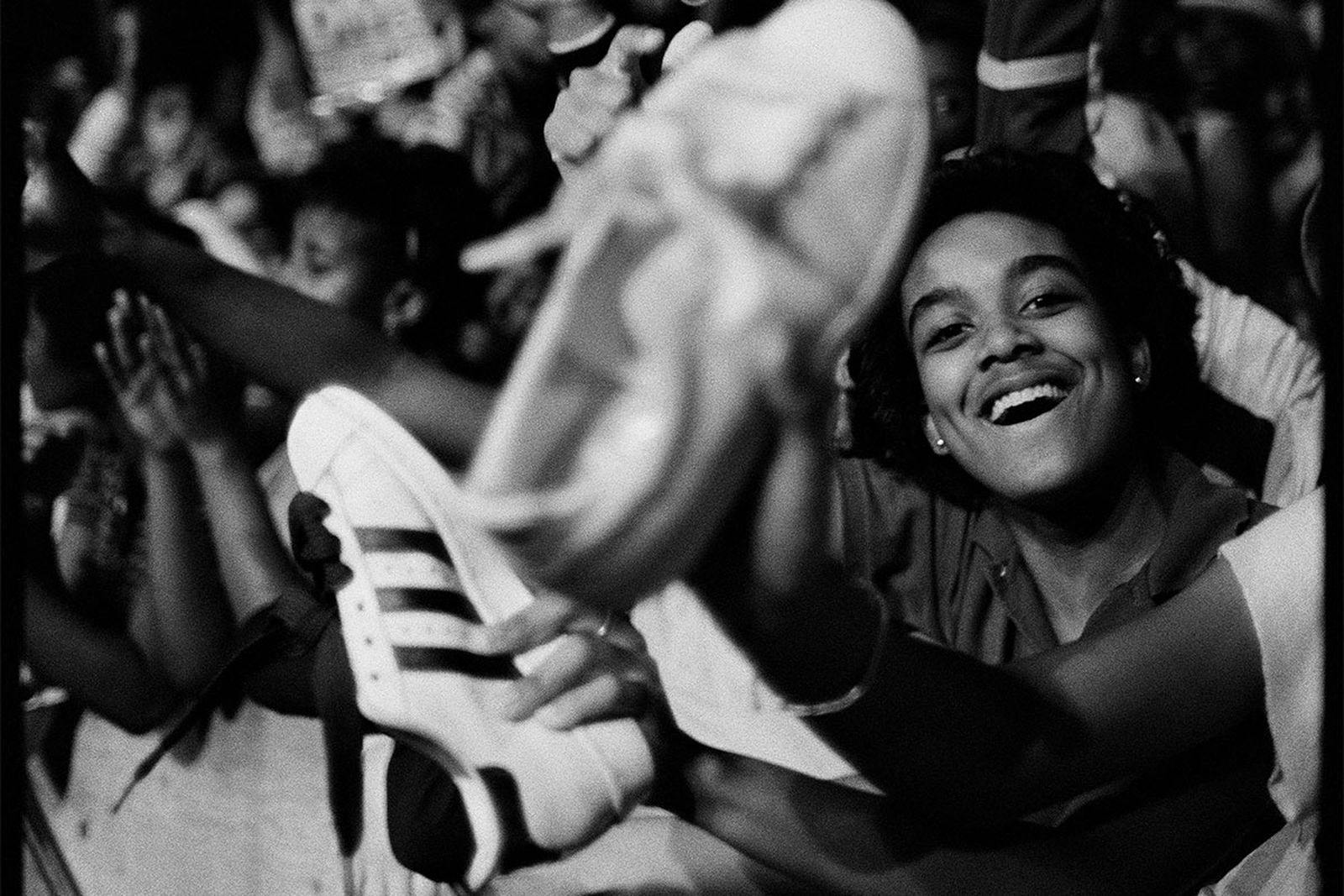 A fan proudly waves his adidas Superstars in the air at a Run-DMC concert.