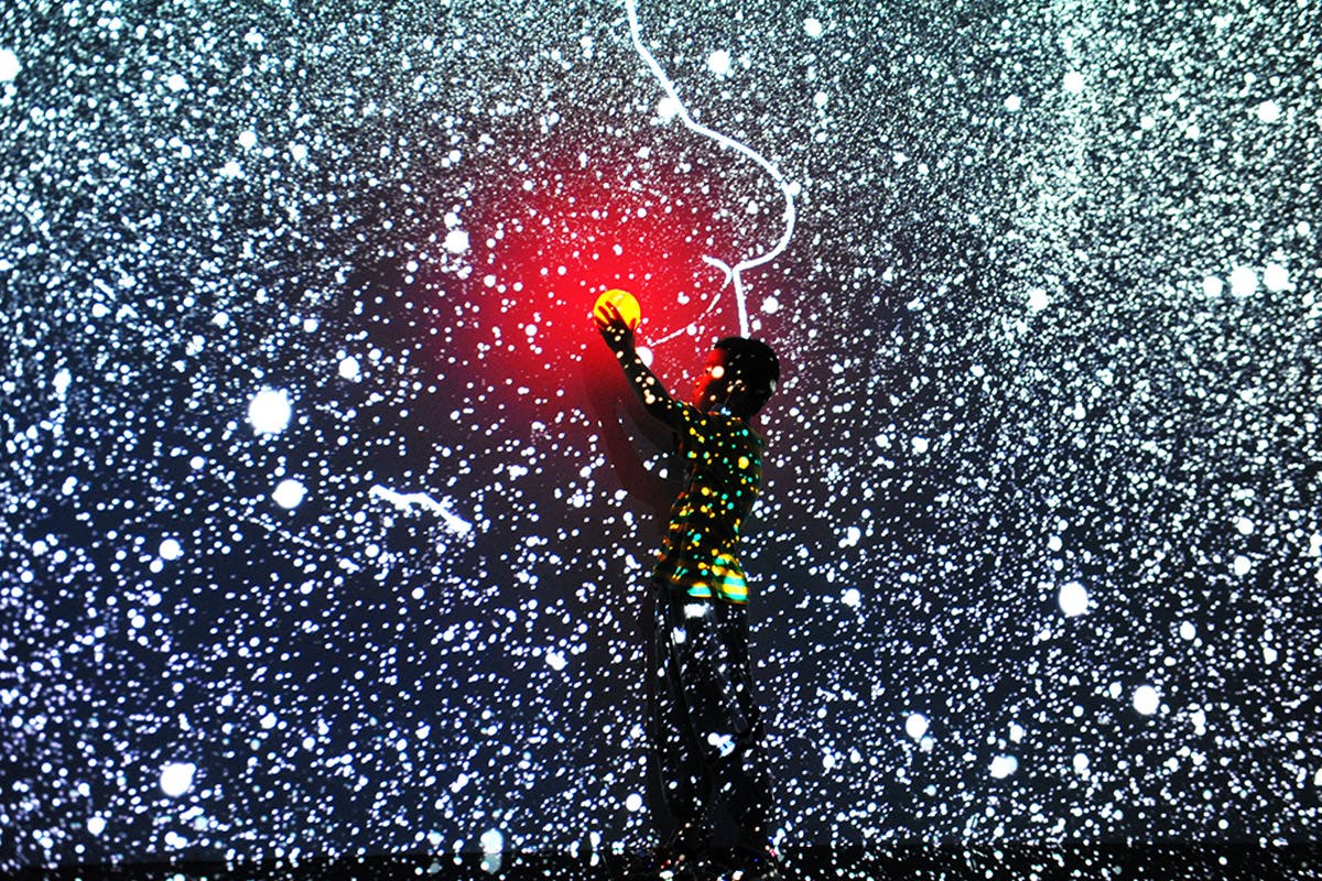 Child reaching for light in digital art exhibition