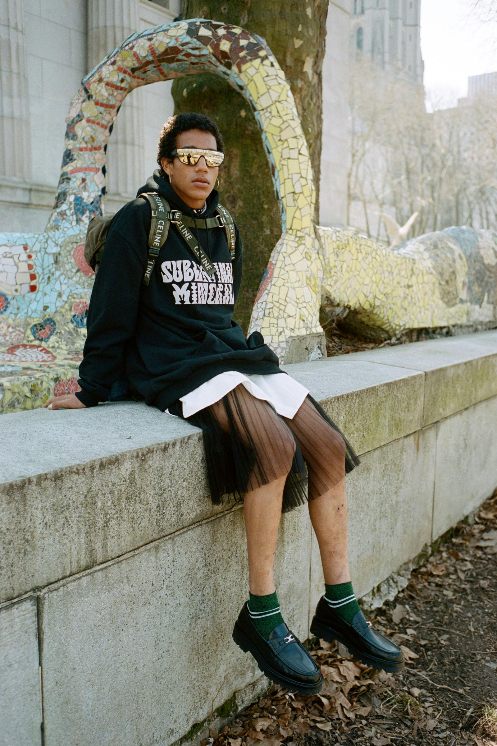 Top, skirt, hoodie, sunglasses, necklace, and shoes CELINE HOMME BY HEDI SLIMANE Trekking Backpack in Cotton Gabardine with Celine Print Khaki CELINE HOMME BY HEDI SLIMANE Earrings and socks MYLES’S OWN