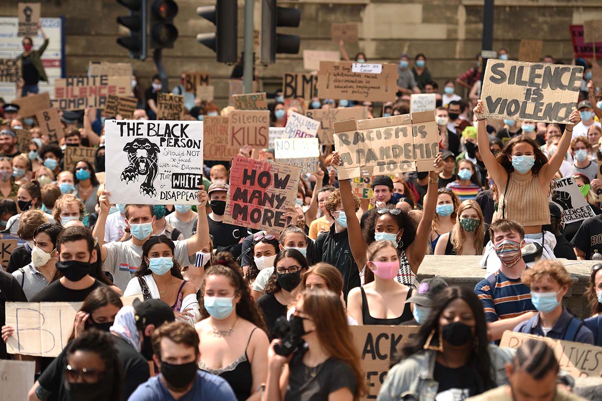 Protesters hold up placards at a gathering in support of the Black Lives Matter