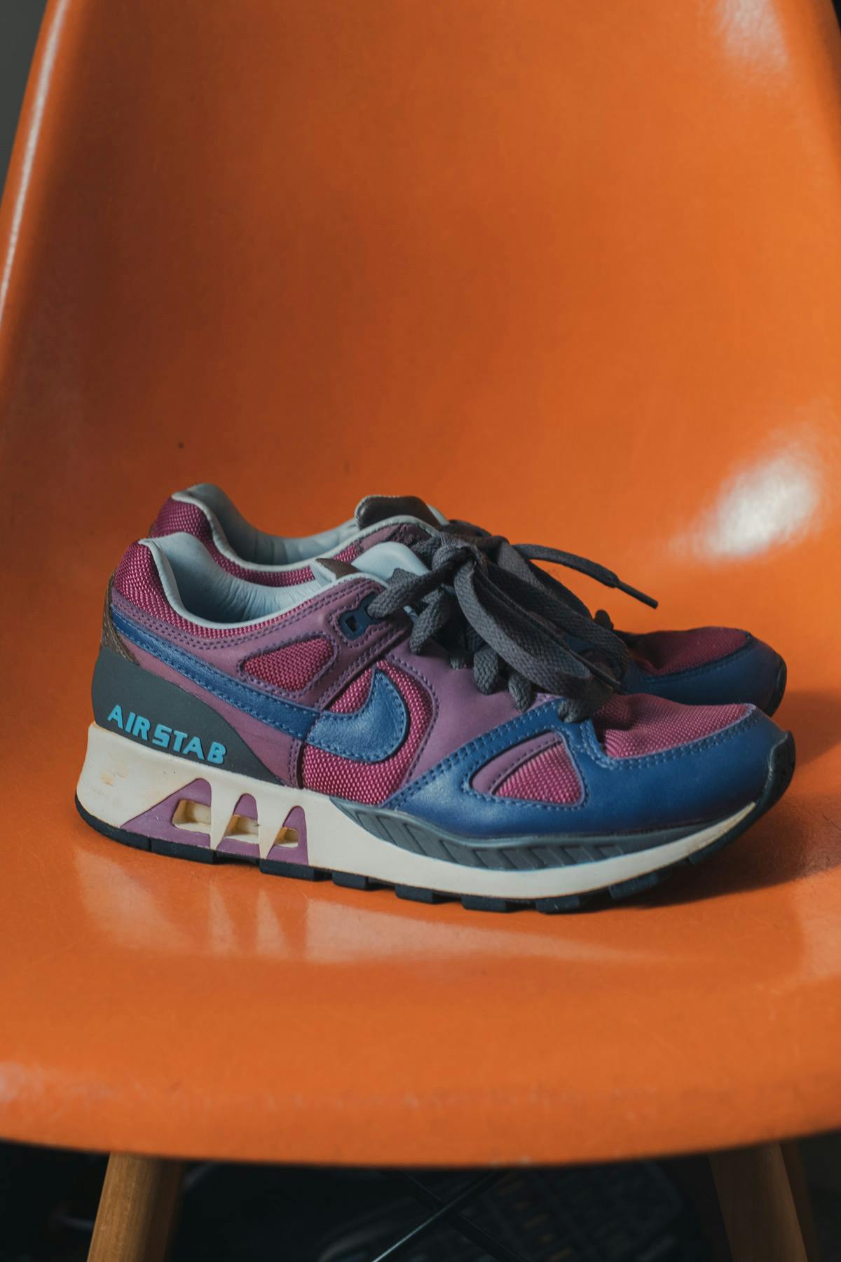 A pair of Nike Air Stabs on an orange chair