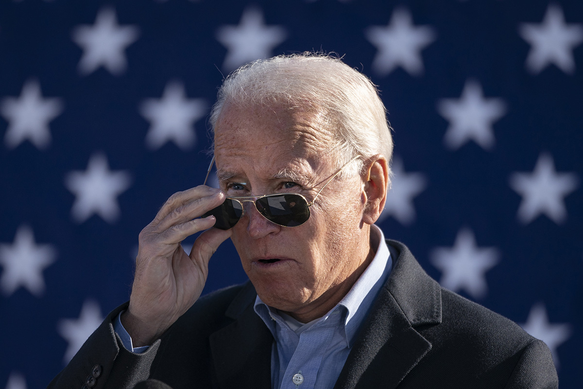 Joe Biden takes off his sunglasses while speaking at a campaign