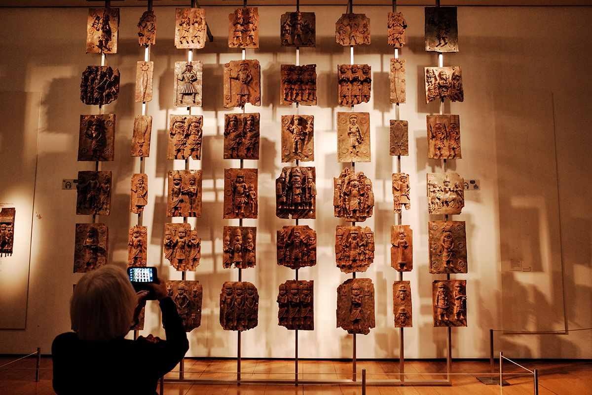  A visitor takes photos of the contentious Benin plaques exhibit (more commonly known as the Benin bronzes) at the British Museum in London.