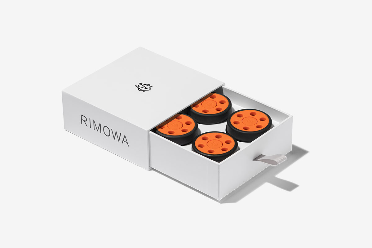 rimowa orange wheels in a box