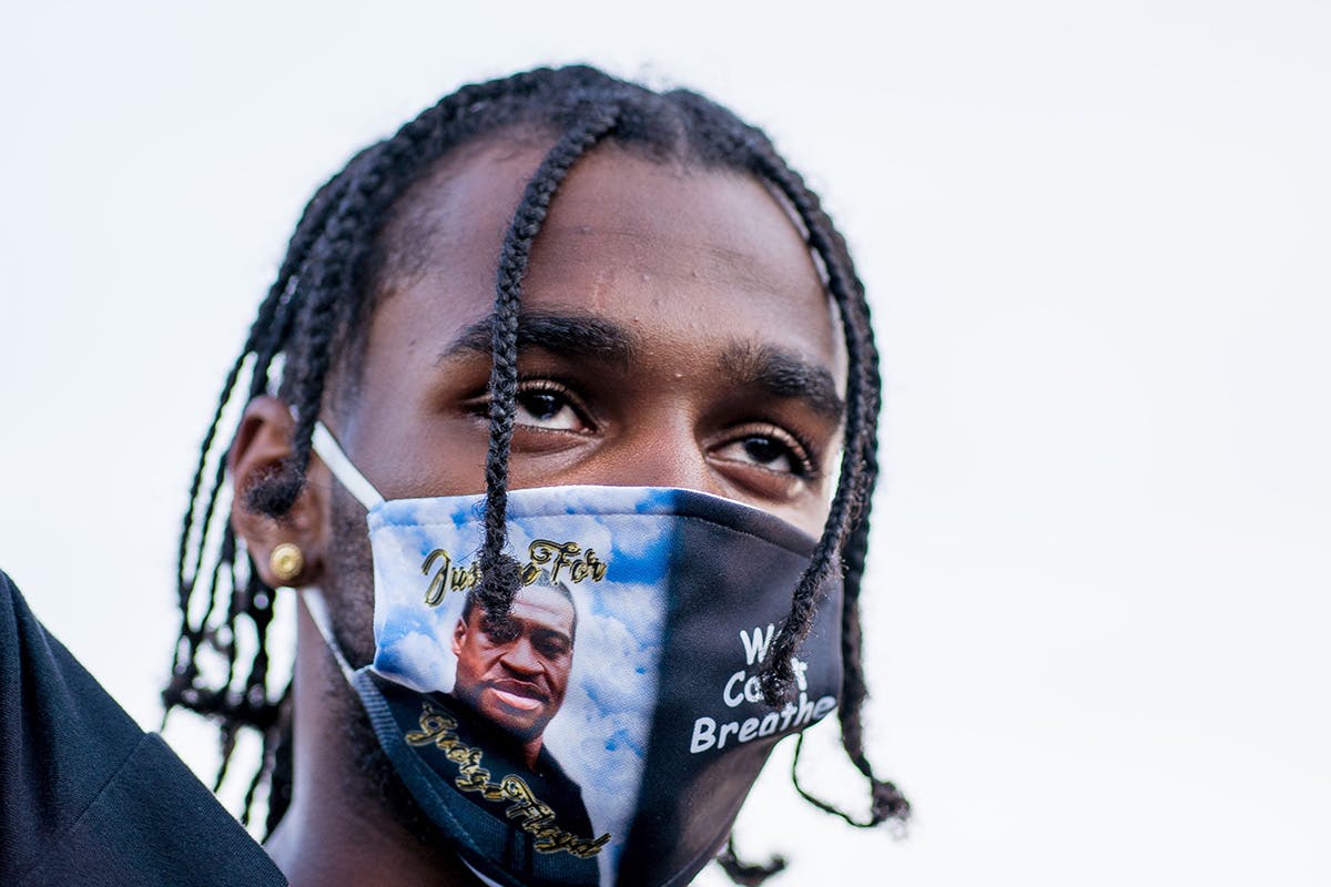 A man raises his hand during a memorial for George Floyd following a day of demonstrations